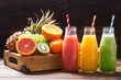 bottles of fruit juice and smoothie with fresh fruits