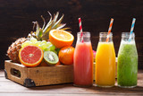 bottles of fruit juice and smoothie with fresh fruits