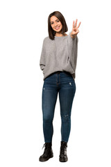 Wall Mural - A full-length shot of a Young woman happy and counting three with fingers over isolated white background