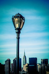 Fototapete - Black city lamp post with New York City Manhattan skyline in the background