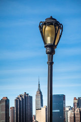 Fototapete - Black city lamp post with New York City Manhattan skyline in the background