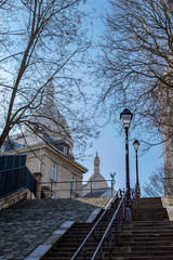 Wall Mural - Typical Montmartre staircase with old street lamp and sacre coeur in background in winter. Paris, France