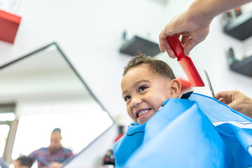 Wall Mural - Cute Boy Getting a Hair Cut in a Barber Shop. Beauty Concept.