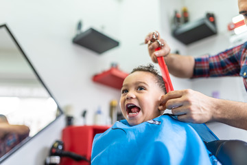 Wall Mural - Cute Boy Getting a Hair Cut in a Barber Shop. Beauty Concept.