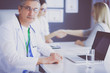 © lenets_tan - Doctor and patient discussing something while sitting at the table . Medicine and health care concept