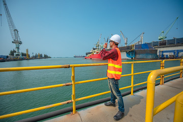 Wall Mural - supervisor, port controller, harbor master or worker  in command on the terminal port for safety and control security during the operation of ship in port