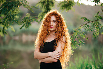 portrait af a beautiful redhead woman outdoors. stylish romantic young girl on a walk in the park. red hair and freckles