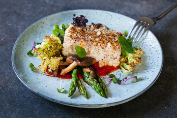 Wall Mural - Halibut with hazelnut crust with roast red pepper sauce, asparagus, cauliflower and shiitake mushrooms