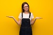 Woman over yellow wall unhappy because not understand something