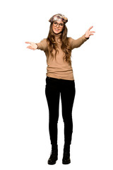 Wall Mural - Full-length shot of Young woman with beret presenting and inviting to come with hand on isolated white background