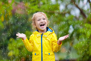 Wall Mural - Kids play in autumn rain. Child on rainy day.