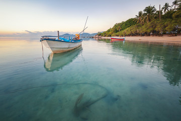 Blue sea at sunset, boat fishing  Shore landscape bay. Summer  scenery. Blue water.