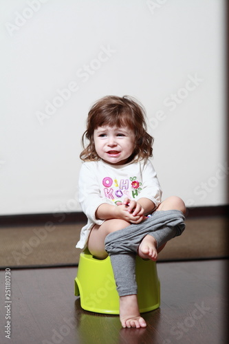 a little girl sits on a potty and makes funny faces - Buy this stock ...