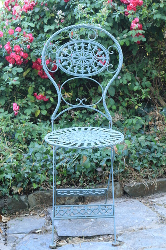 Green Wrought Iron Chair On A Small Patio In Cornwall England A Wrought Iron Chair Painted Green On A Small Patio In Summer At Cornwall England Buy This Stock Photo And