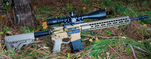 AR-15 With A High Powered Rifle Scope In The Forest