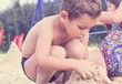 © cameravit - Group of litle cute kids makes sand castle at the beach