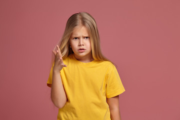 little girl in a yellow t-shirt. hands it inquiringly