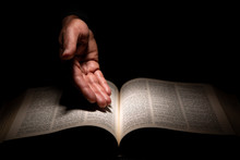 African American Man's Hand Showing To The Bible, The Word Of God.