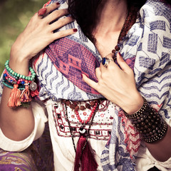 closeup of woman in boho style clothes and jewelry, bracelets necklace and rings outdoor summer
