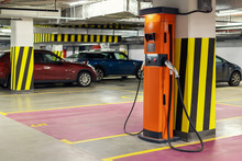 Electric Car Fast Charging Station At Indoor Underground Parking. Power Supply Point Network For Hybrid Electric Car Charging Battery. Eco Green Energy