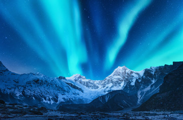 Wall Mural - aurora borealis above the snow covered mountain range in europe. northern lights in winter. night la