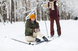 © Seventyfour - Full length portrait of crying young woman sitting on snow injured during skiing, copy space