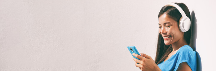 technology young people - asian woman listening to music with headphones and smartphone online with 