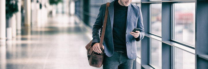 Wall Mural - business man texting on mobile phone commuting walking in airport with messenger bag using cellphone
