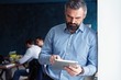 © opolja - Handsome middle age businessman with digital tablet in the modren office.
