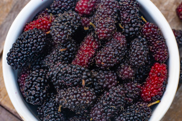 Wall Mural - The mulberry fruit in white bowl on wood table.