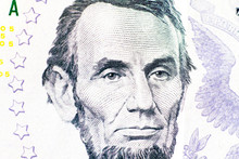 A Close-up Portrait Of Abraham Lincoln Depicted On A Five-dollar Bill.