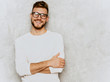 © halayalex - Portrait of handsome smiling hipster lumbersexual businessman model wearing casual summer white clothes. Fashion stylish man posing against gray wall