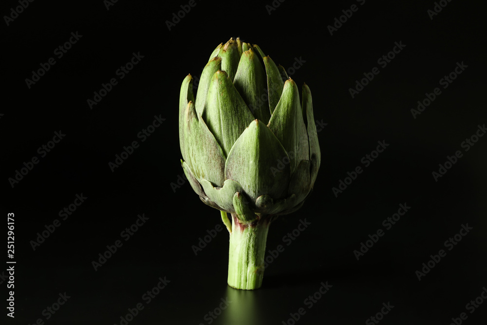 Raw artichoke on black background