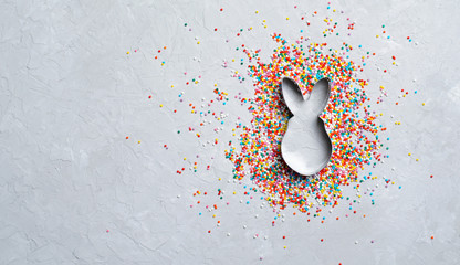 Wall Mural - Easter Concept, Sugar Sprinkles and Cookie Cutter on Grey Background