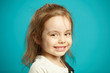 © Ilshat - Caucasian little girl cute smiling, close-up portrait of beautiful child on blue isolated background.