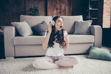 Sticker - Close up portrait beautiful brunette she her lady singing songs having fun free time eyes closed mouth open legs crossed wearing sporty domestic light color t-shirt pants clothes outfit comfy divan