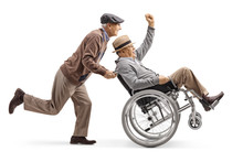 Senior Man Pushing A Positive Disabled Man In A Wheelchair Gesturing With Hand
