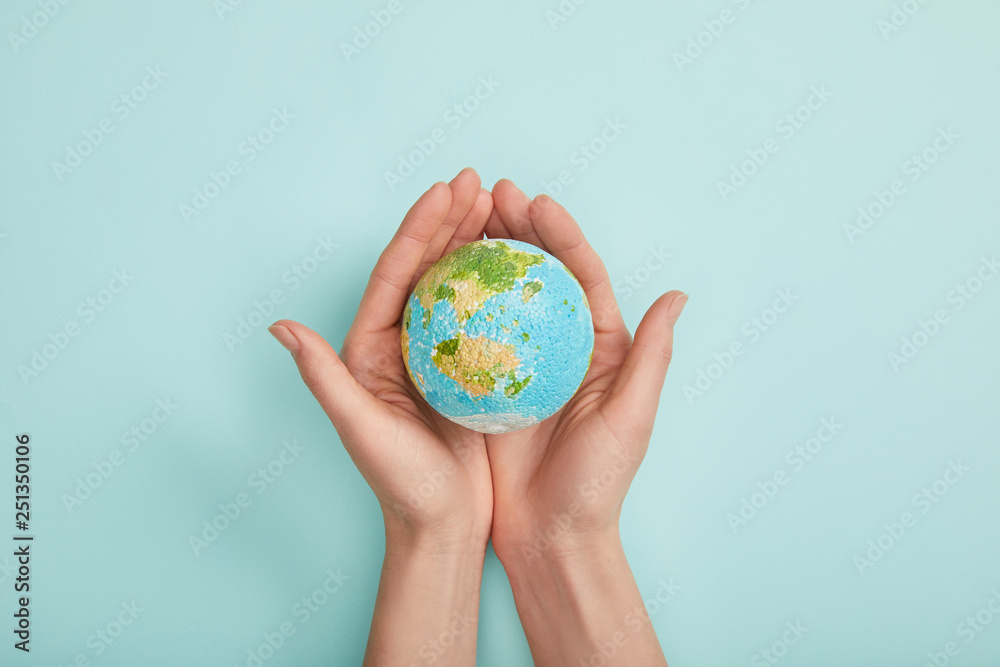 top view of woman holding planet model on turquoise background, earth day concept - obrazy, fototapety, plakaty 