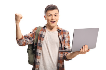 Wall Mural - Excited teenage boy holding a laptop and gesturing with hand