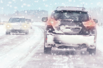 Wall Mural - Winter, snow, Blizzard, poor visibility on the road. Car during a Blizzard on the road with the headlights.