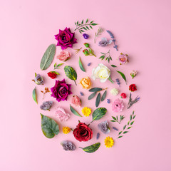 Wall Mural - Easter egg shape made with various spring flowers and leaves on pastel pink background. Minimal Happy Easter concept. Flat lay.