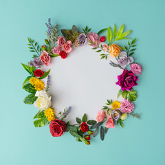 Wall Mural - Spring wreath made of colorful flowers and leaves. Natural round frame layout with paper card. Flat lay.