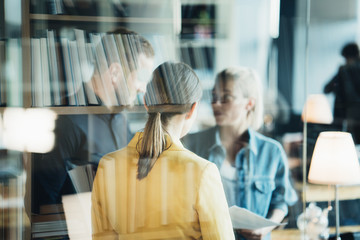 Wall Mural - Two women employees and chief manager discussing new work plans in the office. Double exposure