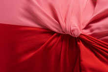 Red And Pink Cloth Stitched Together. Closeup Material Background.
