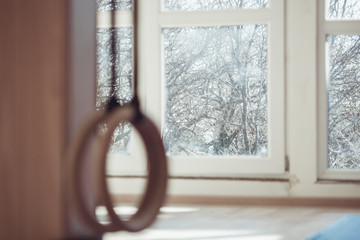 two wooden sport rings in a gym hanging in front of window