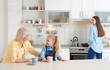 © New Africa - Young woman, her mother and daughter spending time in kitchen