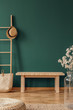 © Photographee.eu - Copy space on the empty green wall of elegant room with wooden ladder with wicker hat and bench