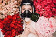 © primipil - Beautiful female enjoying and smelling scent of flowers in gas mask. Allergy protection pharmacy concept.