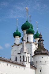 Old white stone orthodox church with green domes and golden crosses