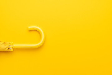 folded umbrella on the yellow background with copy space